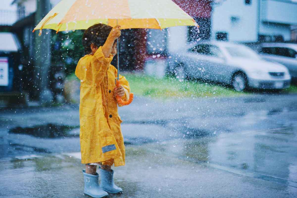 bambino con impermeabile e pioggia