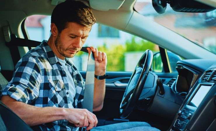 uomo che mette cintura di sicurezza