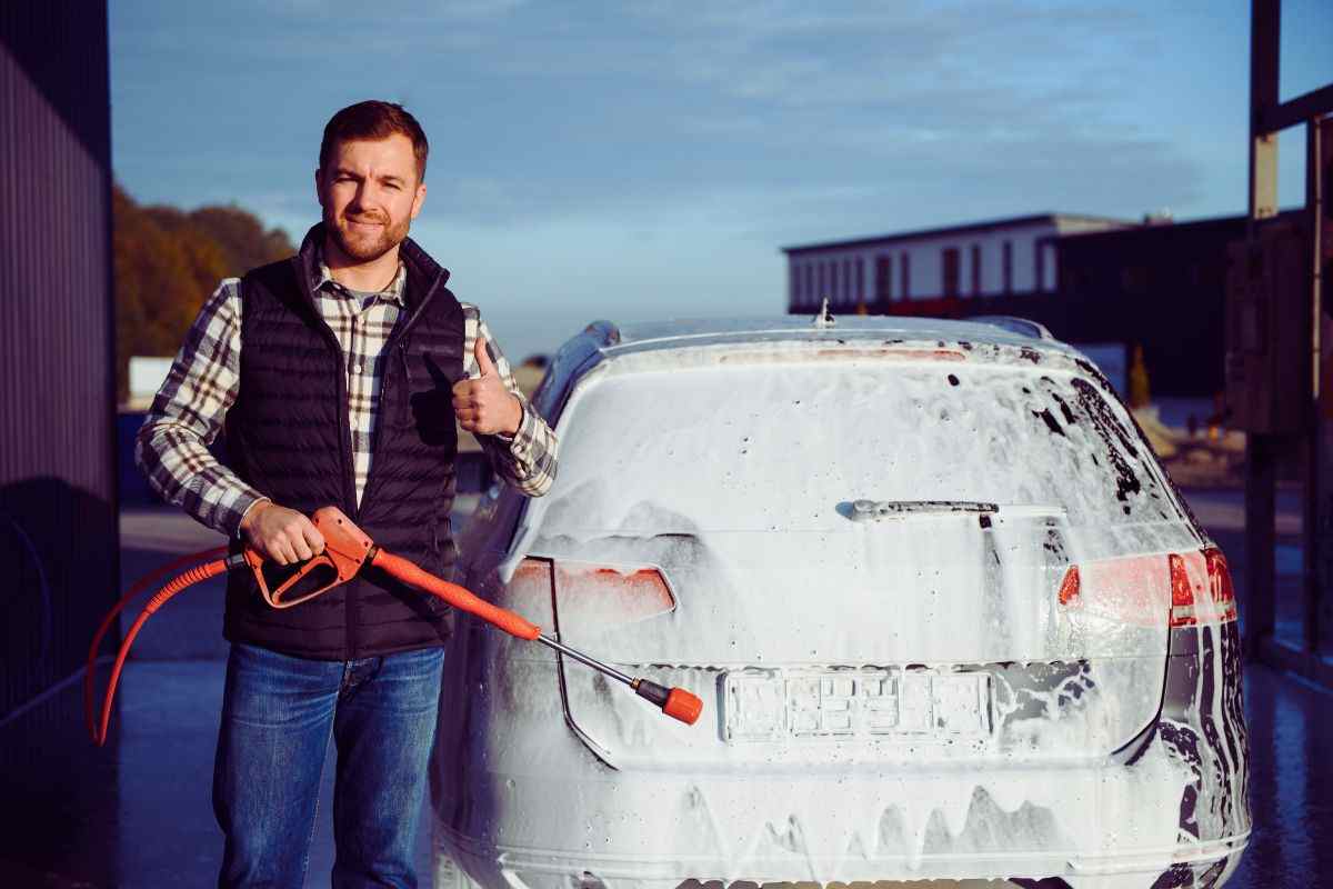 uomo fa ok col pollice e lava auto
