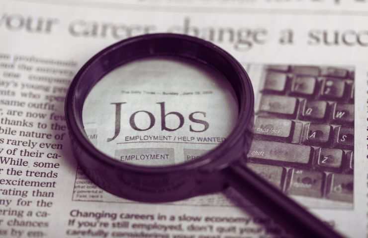 giornale con la lente di ingrandimento sulla parola job