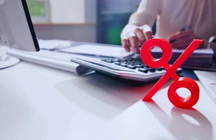 persona fa calcoli e un segno della percentuale