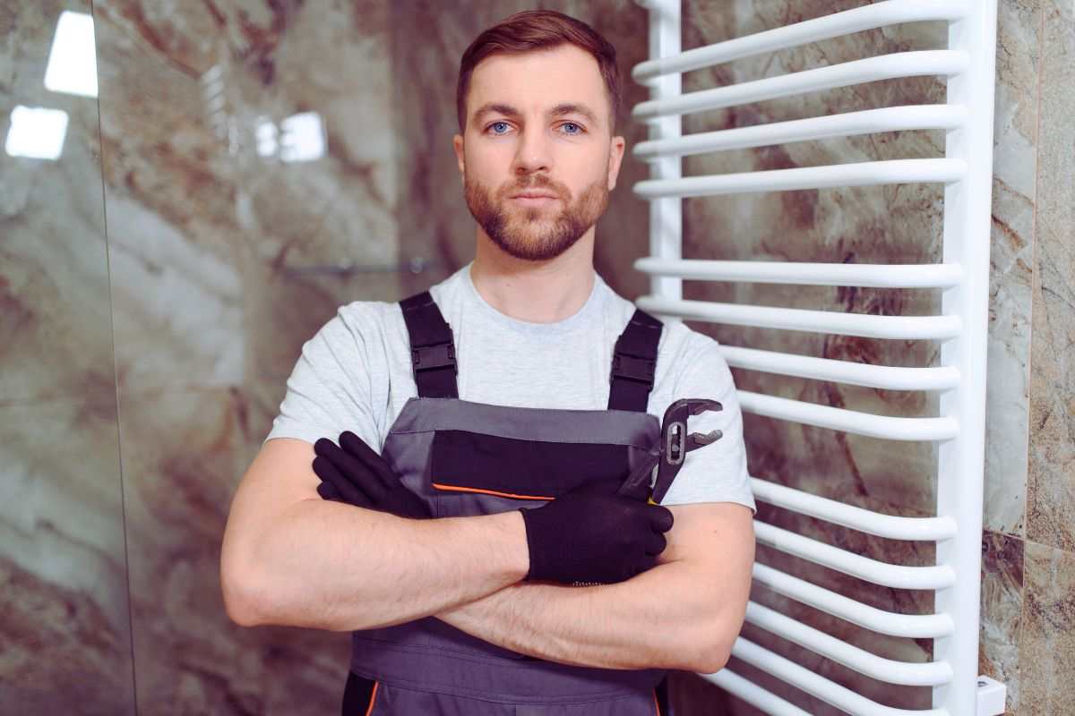 jene-stephaniuk-lkmGeyLItrw-unsplash-ls operaio con dietro termosifone