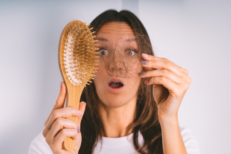 donna con spazzola piena di capelli