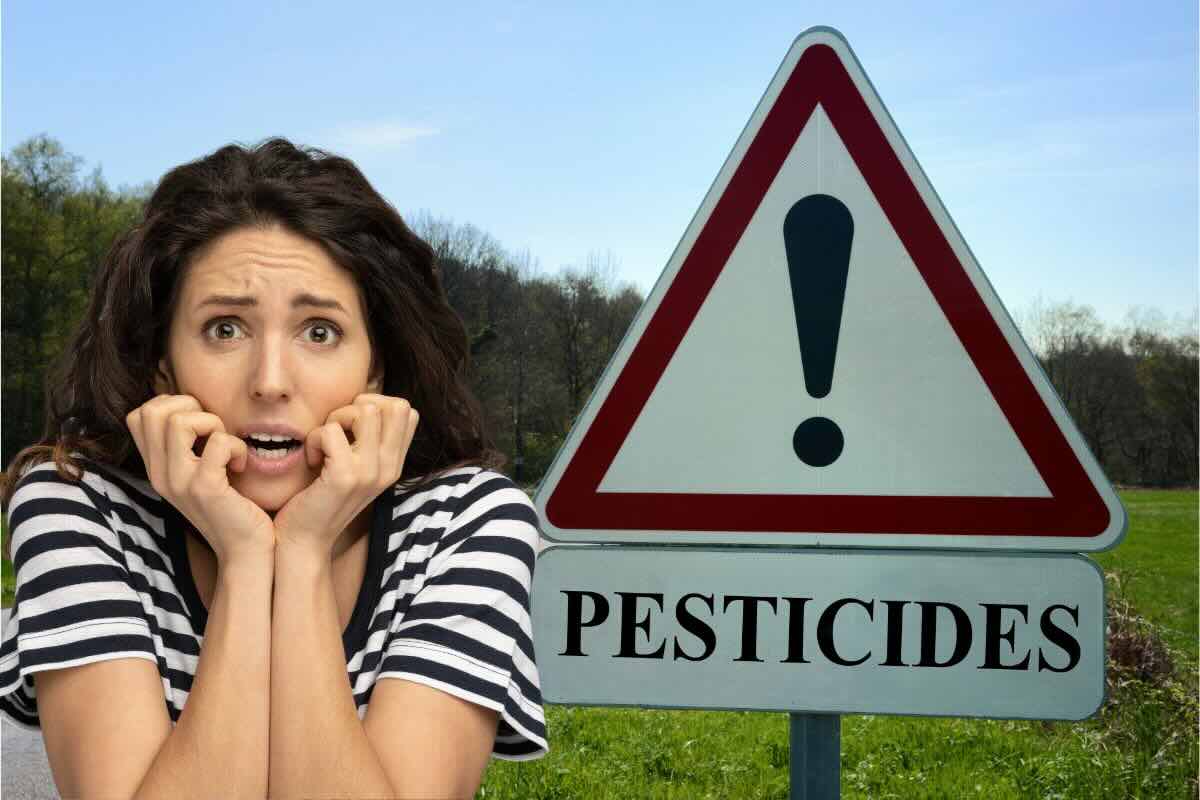 Segnale stop con scritto Pesticidi, donna spaventata