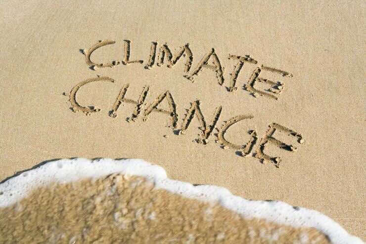 Spiaggia con scritto "climate change" e mare