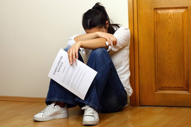 Donna affranta con documento in mano