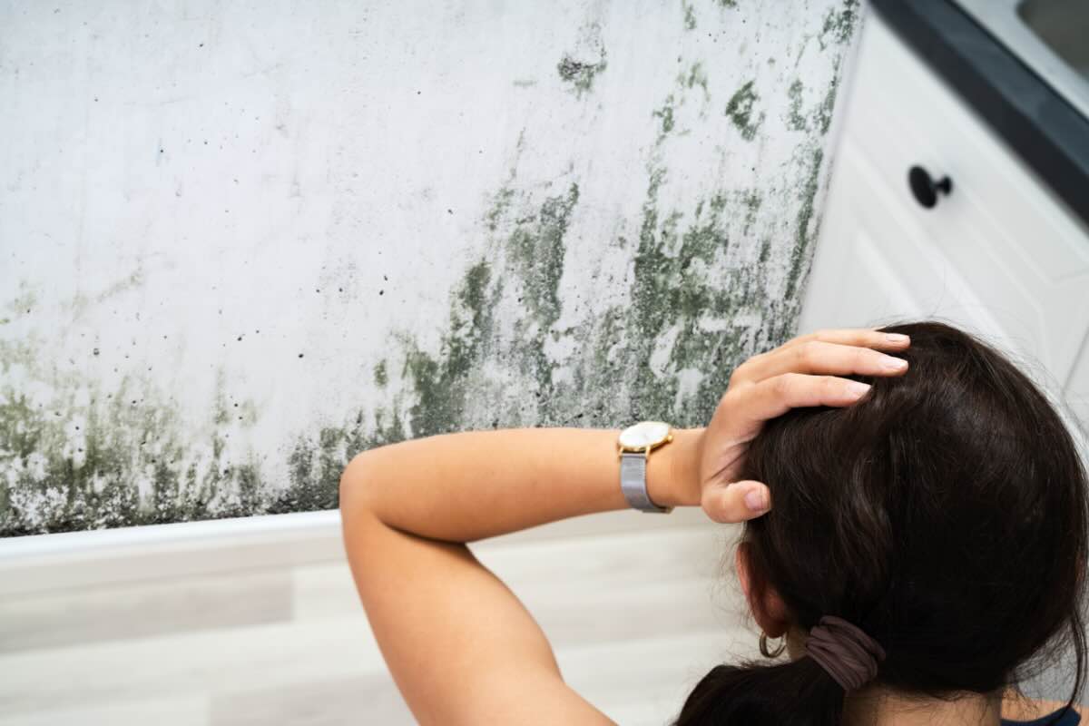 donna che guarda muffa sui muri