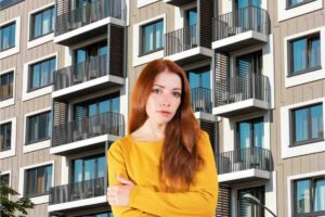 Donna braccia conserte, dietro di lei facciata palazzo