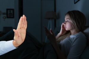 Mano fa stop, ragazza nel letto con telefono
