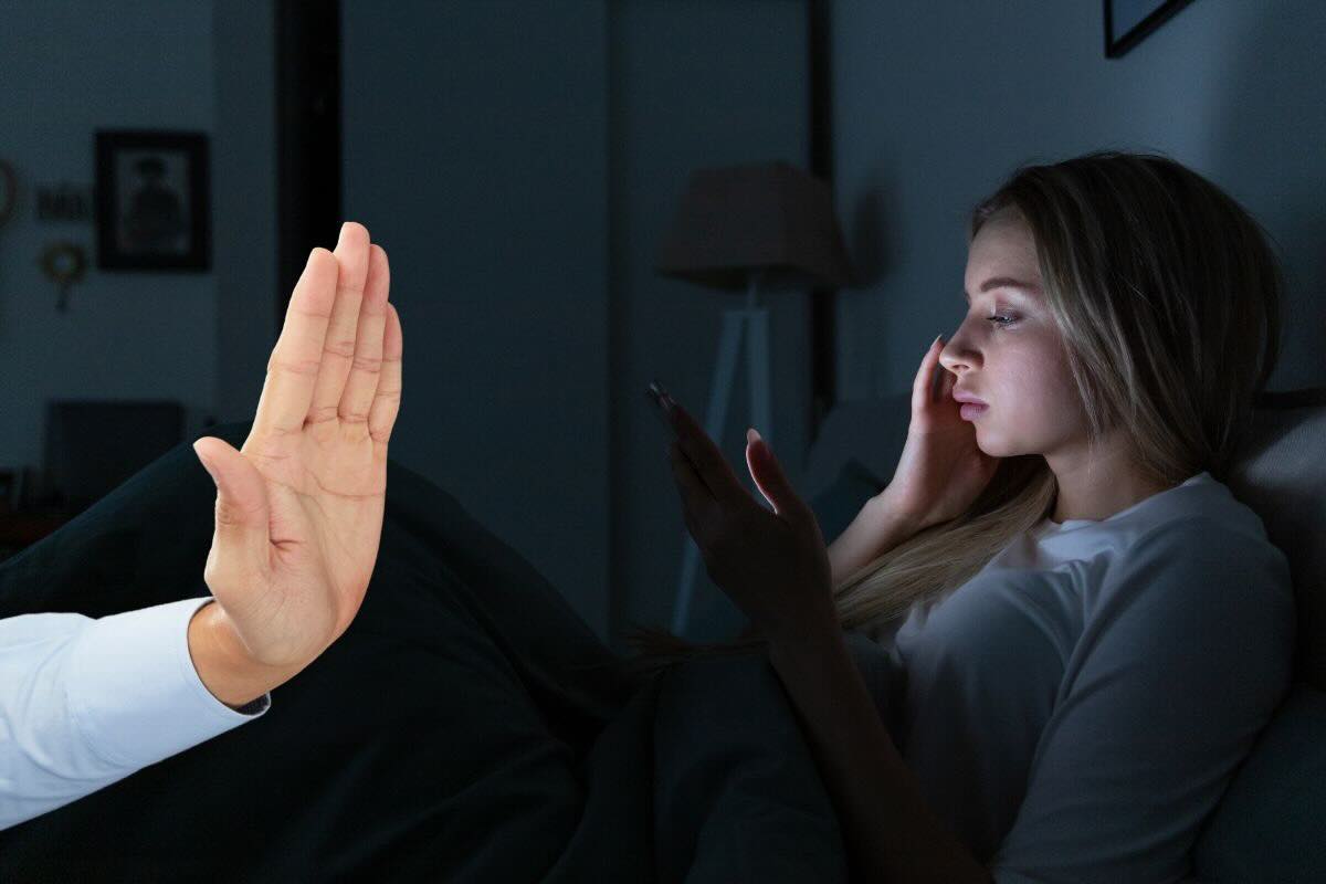 Mano fa stop, ragazza nel letto con telefono