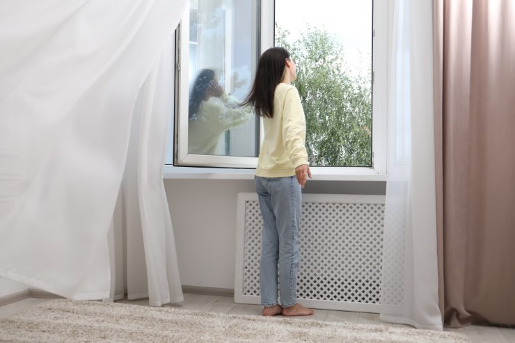 donna davanti a finestra aperta