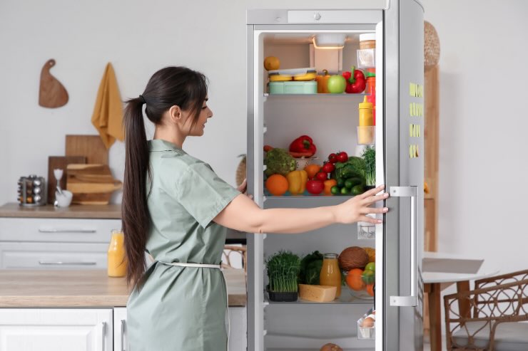 donna che apre il frigo 