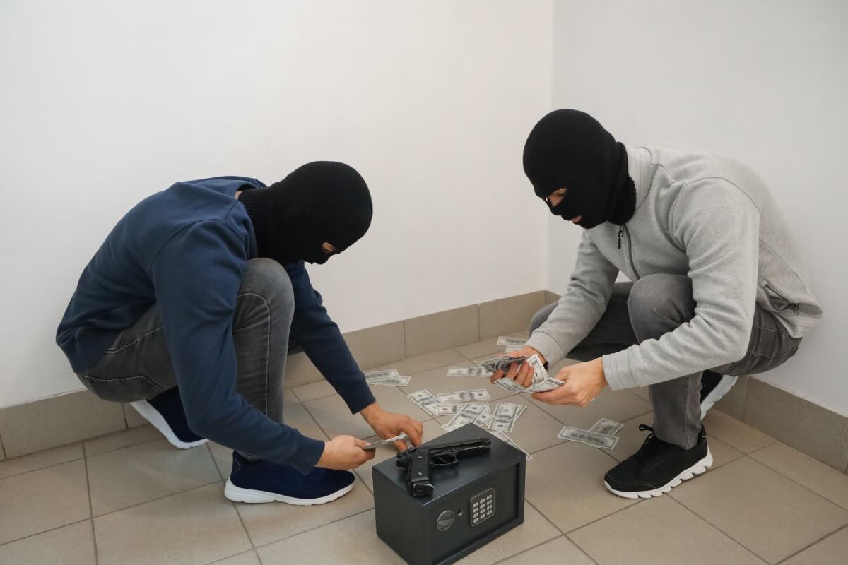 ladri seduti a terra con bottino