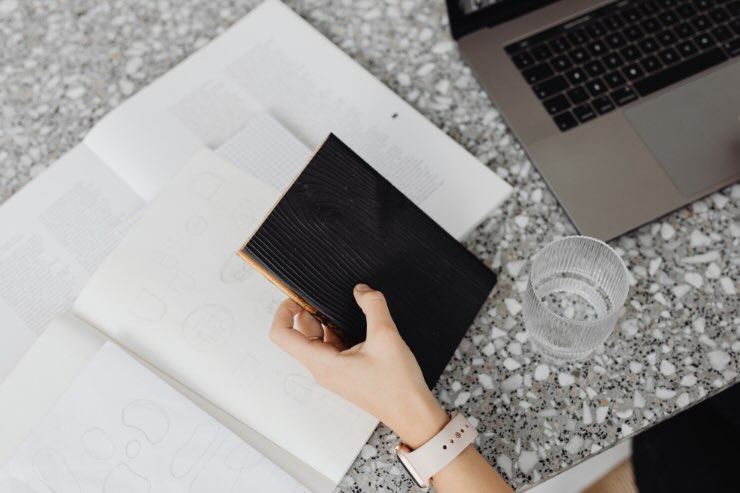 mano con libretto nero e pc