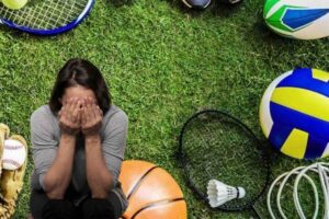 Donna piange, su campo di erba tutti gli strumenti sportivi