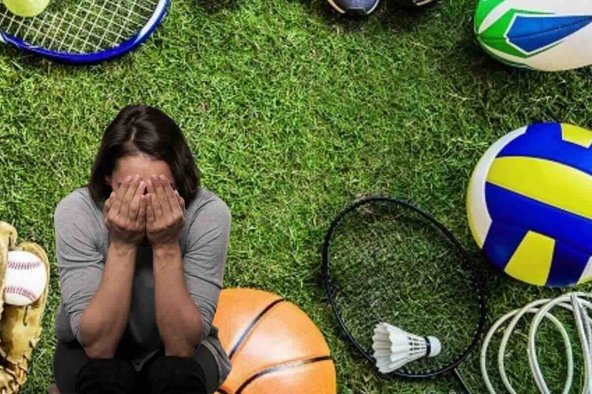 Donna piange, su campo di erba tutti gli strumenti sportivi