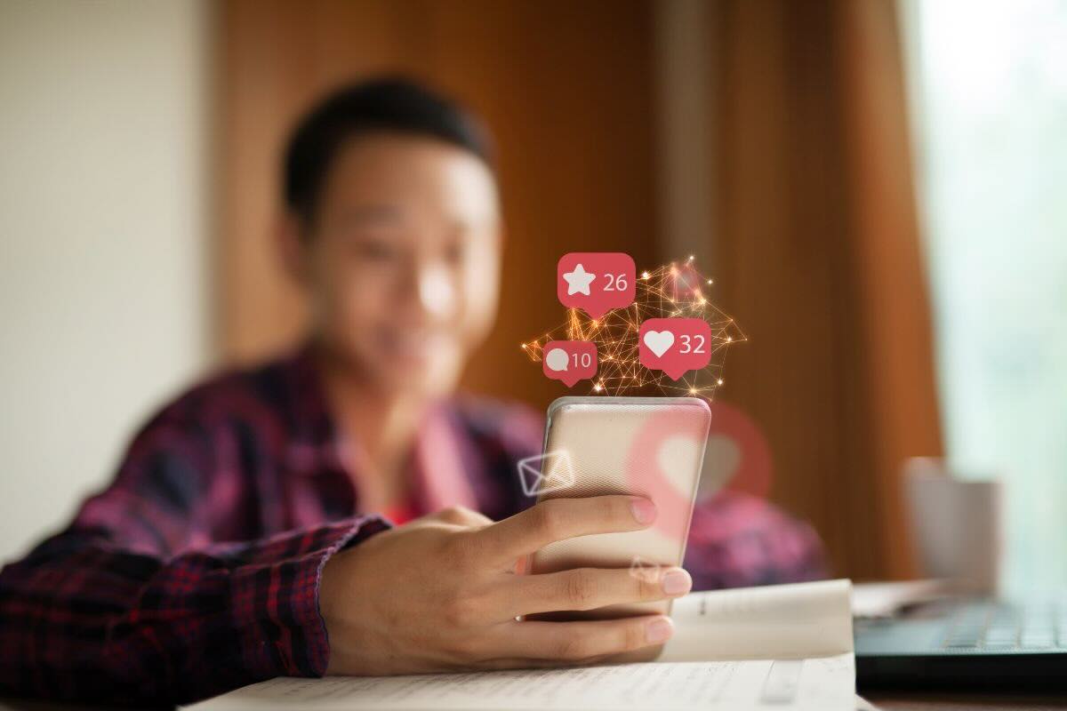 Ragazzo con smartphone, reazioni cuore social