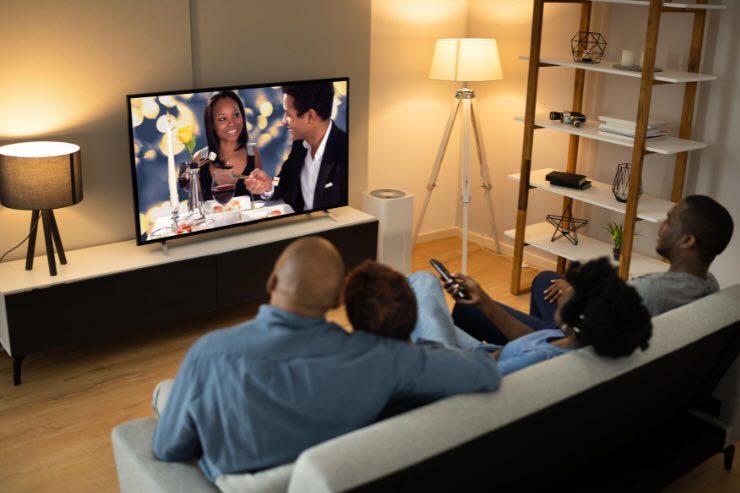 persone che guardano la tv sul divano