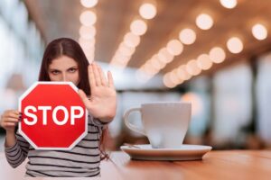 tazza di caffè e donna con segnale stop