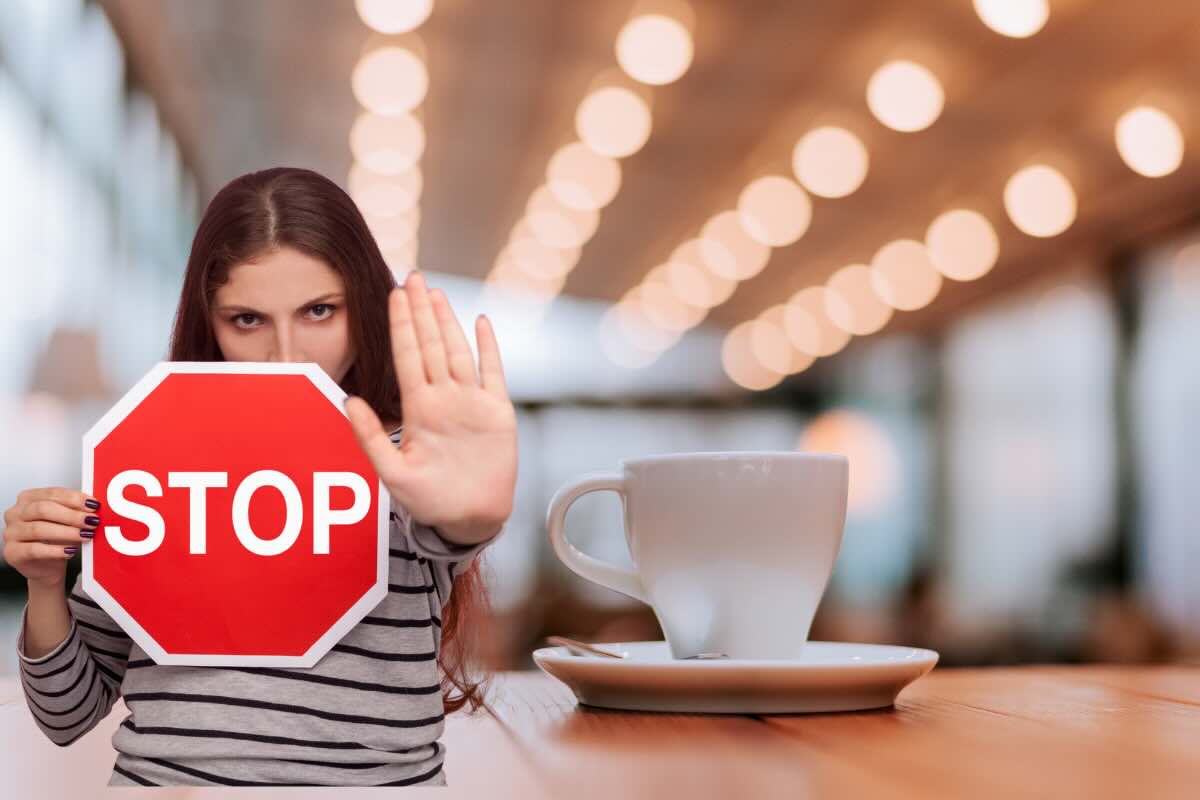 tazza di caffè e donna con segnale stop