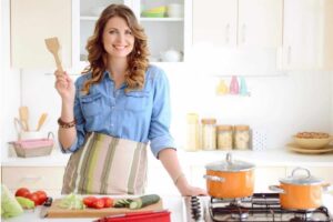 Donna con mestolo in cucina, verdure sul tagliere