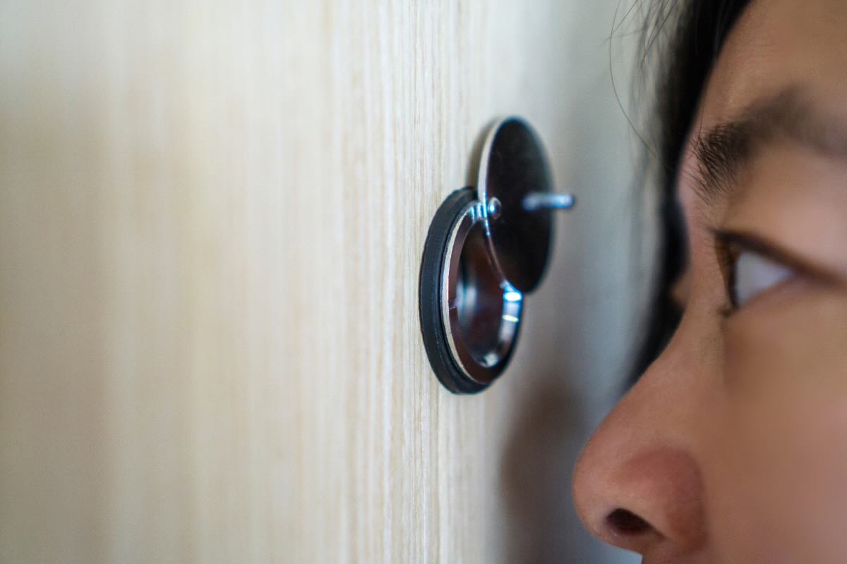 uomo che guarda attraverso spioncino