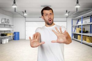 Uomo fa stop con le mani, garage alle sue spalle