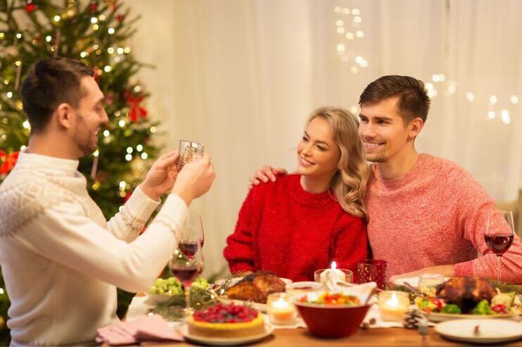 Ragazzo scatta foto a coppia cena Natale
