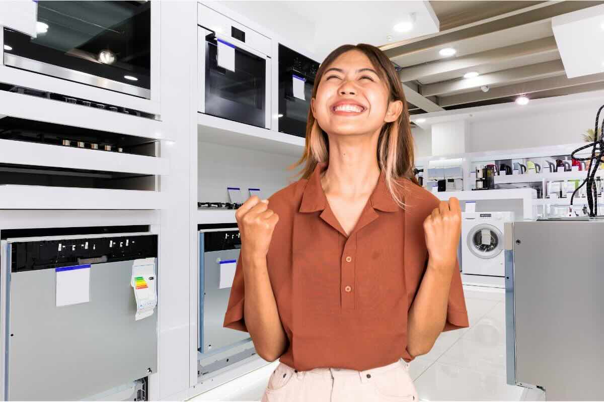 Donna esulta, elettrodomestici dietro di lei