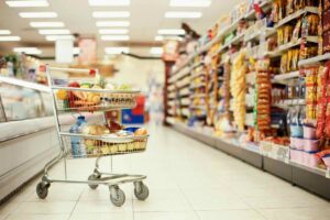 scaffali del supermercato e carrello della spesa pieno