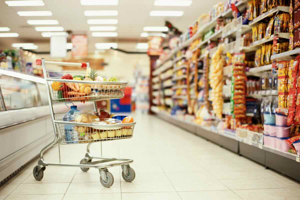 scaffali del supermercato e carrello della spesa pieno