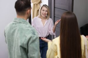 signora bionda che saluta coppia di spalle