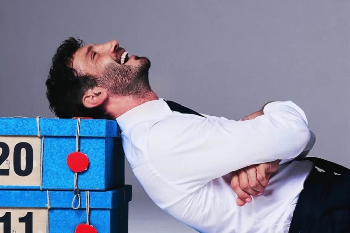 Stefano De Martino che sorride sui pacchi di affari tuoi