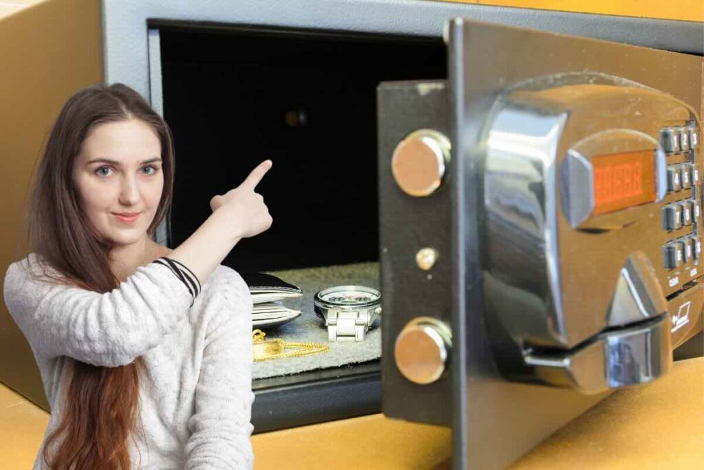 Donna indica interno di cassaforte con orologio e portafoglio