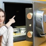 Donna indica interno di cassaforte con orologio e portafoglio