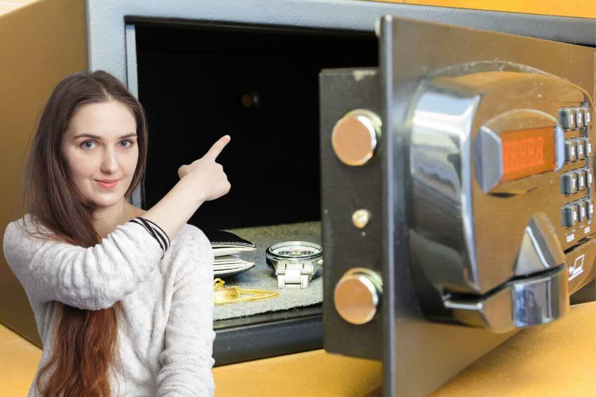 Donna indica interno di cassaforte con orologio e portafoglio