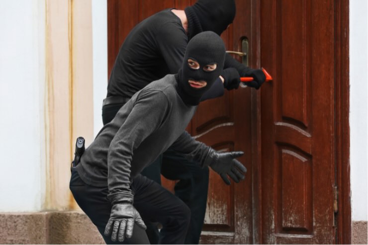 un uomo vestito di nero che guarda e uno che cerca di aprire una porta marrone