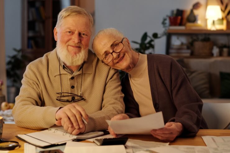 due anziani sorridenti e con fogli in mano